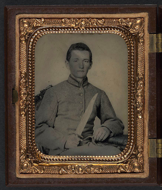 [Unidentified soldier in Confederate artillery uniform with large Bowie knife; badge for 1907 reunion of United Confederate Veterans, Richmond, also in case] (LOC)