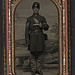 [Unidentified soldier in Union sergeant's uniform standing with revolver and cartridge box in front of painted backdrop showing countryside landscape] (LOC)