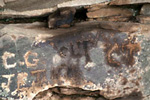 Detail of a rock wall with initials on it.