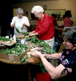 Three women around a table, cleaning ramps.