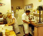 Rocco and his mother working at counters in a large kitchen