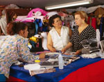 Three women at a work table with fabrics