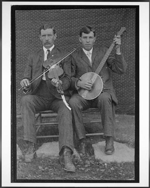 Two men, one playing a fiddle, one playing a banjo.