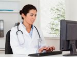 Young female doctor working at computer