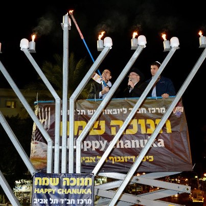 Photo: U.S. Ambassador to Israel Daniel Shapiro lights the menorah in Dizengoff Square in Tel Aviv, Israel, December 12, 2012. [State Department photo by Matty Stern/ Public Domain]