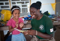 Red Cross woman teaching a little girl to become a Master of Disaster