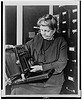 [Frances Benjamin Johnston, three-quarter length portrait, holding and looking down at camera, facing slightly left] (LOC) by The Library of Congress
