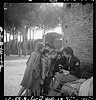 [Toni Frissell, sitting, holding camera on her lap, with several children standing around her, somewhere in Europe] (LOC) by The Library of Congress