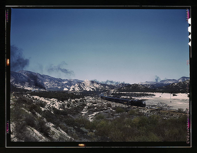 Santa Fe R.R. trains going through Cajon Pass in the San Bernardino Mountains, Cajon, Calif. On the right, streamliner "Chief" going west; in the background, on the left, a freight train with a helper engine, going east. Santa Fe trip (LOC)