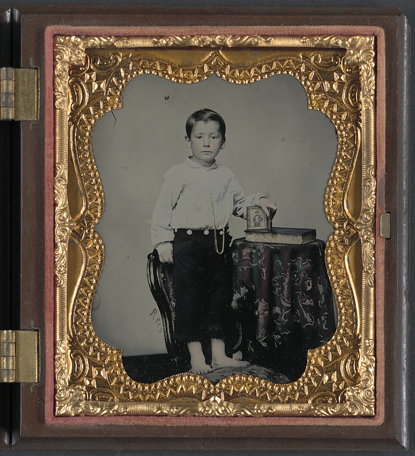 [Unidentified boy holding cased photograph of soldier in Confederate uniform atop a Bible] (LOC)