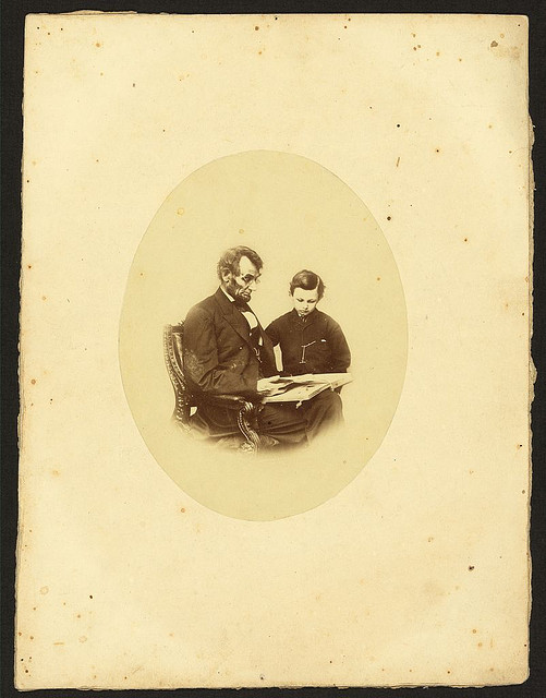 [Abraham Lincoln, U.S. President, looking at a photo album with his son, Tad Lincoln, Feb. 9, 1864] (LOC)