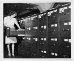 Jeannette Poirier looking at photographs in file cabinet drawer at the Washington office of the Overseas Branch of the U.S. Office of War information, LC-DIG-ppmsca-03084