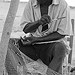 A man mending his fishing nets on the beach in Port Salut
