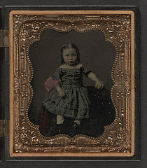 [Unidentified girl in dress holding American flag and ball] (LOC)