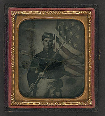 [Unidentified soldier in Union uniform with bayoneted musket in front of American flag] (LOC)