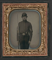 [Unidentified soldier in Union sergeant's uniform and Company H forage cap with revolver, musket, and attached U.S. Model 1862 "Zouave" sword bayonet] (LOC)