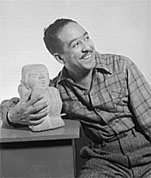 Langston Hughes posing with a small sculpture.