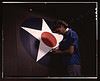 A candid view of one of the women workers touching up the U.S. Army Air Forces insignia on the side of the fuselage of a "Vengeance" dive bomber manufactured at Vultee's Nashville division, Tennessee (LOC) by The Library of Congress