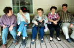 A group of people sitting on a porch.