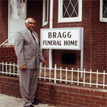 Bragg standing in front of Bragg Funeral Home