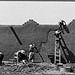 Spanish-American women replastering an adobe house. This is done once a year. Chamisal, New Mexico (LOC)