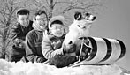 A family and their dog prepare for a descent down the hill on a toboggan, Milwaukee, 1956