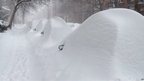 Parked cars hide under mounds of snow on Darling Street in Montreal 27 December 2012