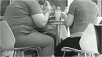 Obese people eating at table