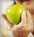 senior woman holding green apple