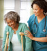 nurse helping woman on crutches