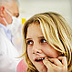 Young woman holding lip at dentists office