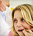 Young woman holding lip at dentists office