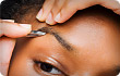 woman plucking eyebrows