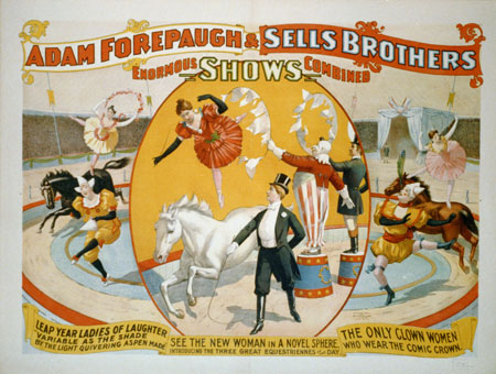 Women circus performers and clowns with woman ringleader wearing tuxedo and top hat.