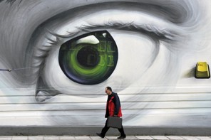 A man walks by a wall adorned with graffiti in Athens on march 8, 2012. Greece added up pledges by private debt holders to cancel half the money owed to them in a tense countdown to an evening deadline critical for a new bailout and to cooling the eurozone crisis.    AFP PHOTO/ TOPSHOTS/ LOUISA GOULIAMAKI (Photo credit should read LOUISA GOULIAMAKI/AFP/Getty Images)