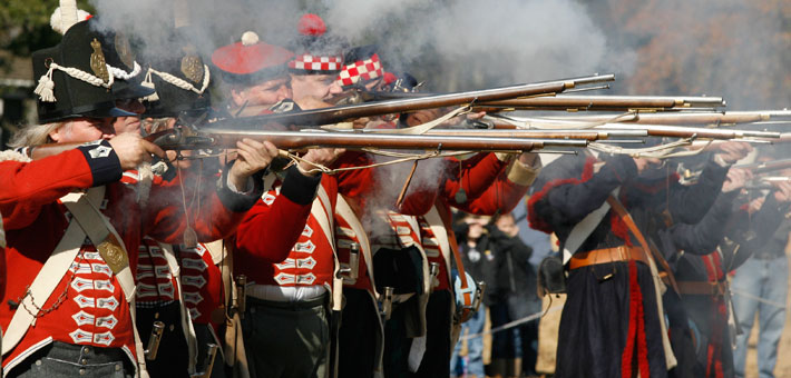 Photo of British troop reenactors firing a volley