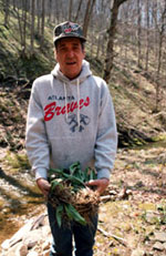 A man holding a handful of plants.