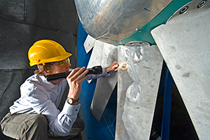 Worker inspecting a part in factory.