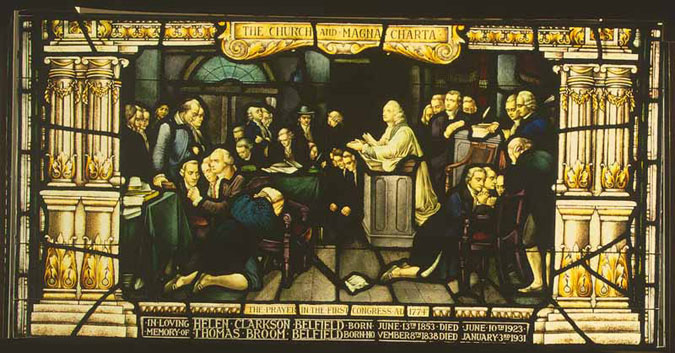 Image of a stained glass window showing members of the first Congress kneeling in prayer.