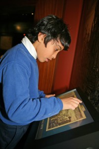 Student examines a touch-screen in 'Exploring the Early Americas'