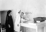 Nurse and woman with a child on a scale