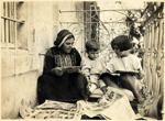 Woman and two children looking at newspapers