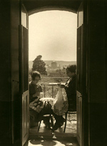 Two women sitting on a balcony making lace