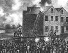 Engraving of a mob in the street near a warehouse.