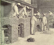 African-American men in workclothes, laying bricks, illustration from 'My Larger Education'.