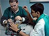 Two teenage boys working on a robotic rover