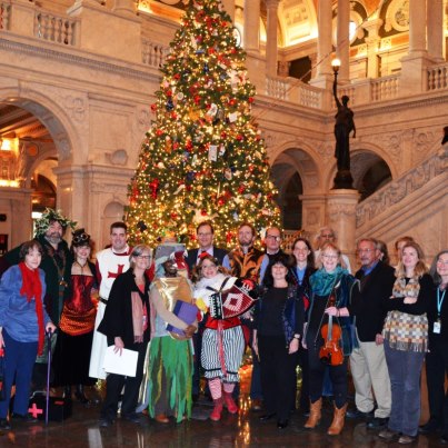 Photo: The American Folklife Center staff, including the AFC Mummers, wish all of our friends a very happy holiday season.  On December 18 and 19, members of the AFC staff presented a mummers play, derived from texts collected in Britain, which are part of AFC's James Madison Carpenter Collection.  One of the venues for the play was the Great Hall of the Library of Congress, next to the Library's Christmas tree.  After the play, the costumed mummers joined the rest of the staff for this group photo.