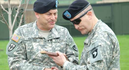 Master Sgt. Jeffrey Mittman, wounded by a roadside bomb in Baghdad, Iraq, receives an award from Col. Craig S. Cotter at the Rock Island Arsenal Joint Manufacturing and Technology Center, May 2009