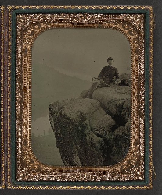 [Unidentified soldier in Union officer's uniform at Point Lookout, Tennessee, sitting with cavalry saber in hand and slouch hat resting beside him on a rock] (LOC)