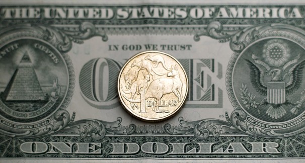 An Australian $1 coin stands on a U.S. $1 note. (Tim Wimborne - Reuters)